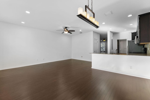 unfurnished living room featuring dark hardwood / wood-style floors, sink, and ceiling fan