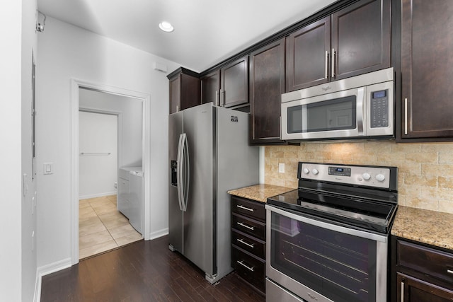 kitchen with appliances with stainless steel finishes, backsplash, dark brown cabinetry, wood-type flooring, and washer and dryer