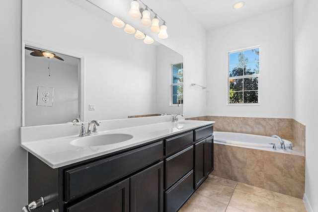 bathroom with vanity, a relaxing tiled tub, tile patterned floors, and ceiling fan