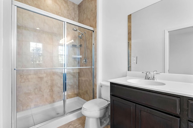 bathroom with vanity, toilet, and a shower with shower door