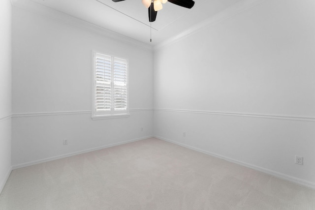 spare room with crown molding, ceiling fan, and light carpet