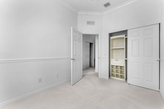 unfurnished bedroom with light carpet, ornamental molding, and a closet