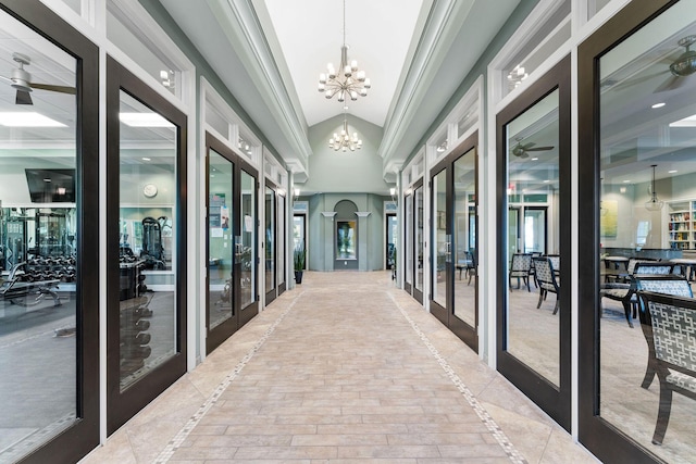 hall with vaulted ceiling, an inviting chandelier, and french doors