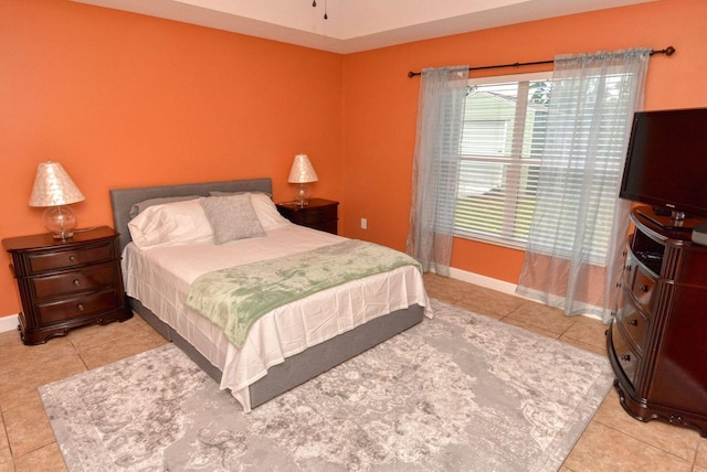 bedroom with light tile patterned floors and baseboards