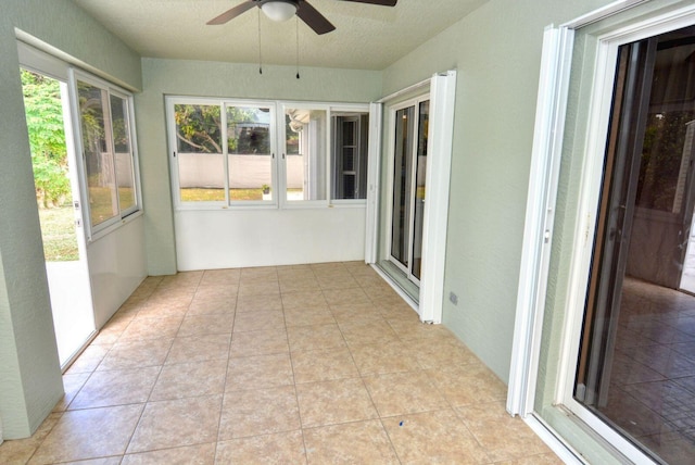 unfurnished sunroom featuring ceiling fan