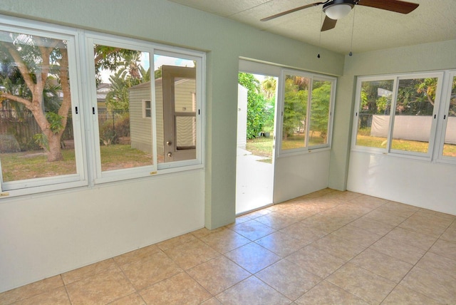 unfurnished sunroom with plenty of natural light and ceiling fan