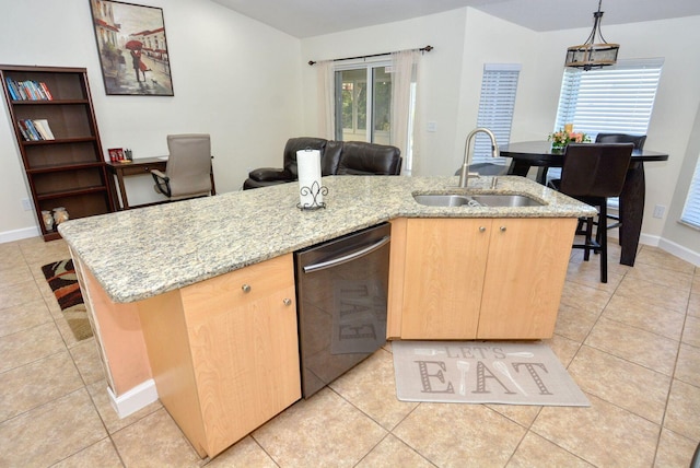 kitchen featuring a kitchen island with sink, light brown cabinets, a sink, stainless steel dishwasher, and light tile patterned floors