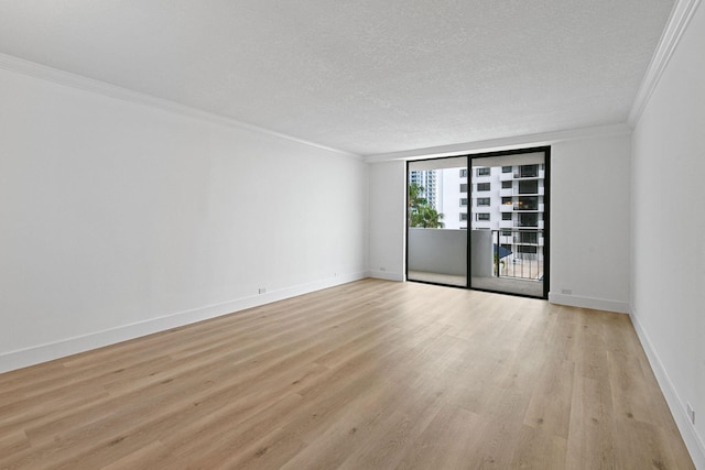 empty room featuring ornamental molding, a textured ceiling, and light hardwood / wood-style flooring