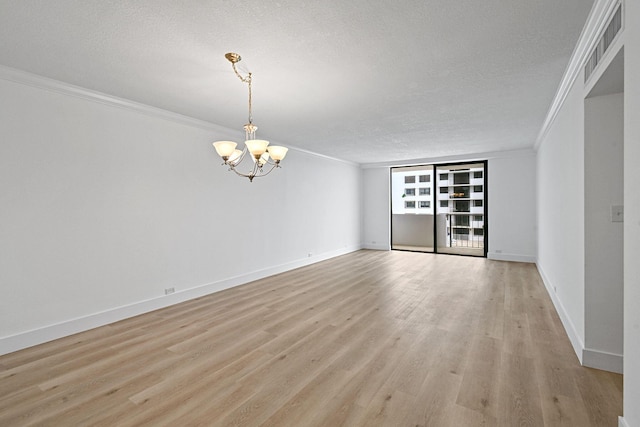 unfurnished room featuring a chandelier, a textured ceiling, light wood-type flooring, and crown molding