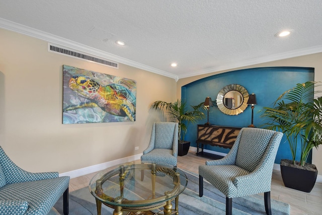 living area featuring crown molding, light hardwood / wood-style floors, and a textured ceiling