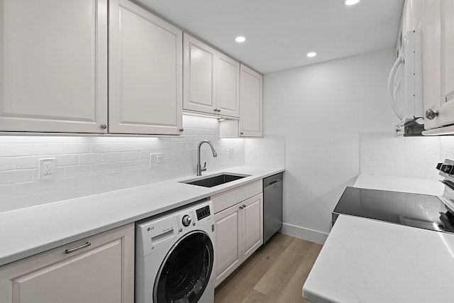 kitchen featuring white cabinetry, sink, washer / clothes dryer, and range