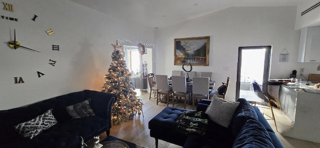 living room with light wood-type flooring and vaulted ceiling