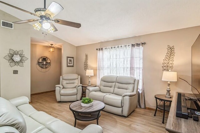 living room featuring ceiling fan, light hardwood / wood-style floors, and vaulted ceiling