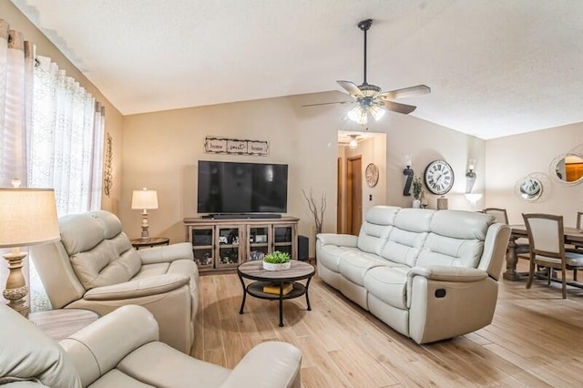 living room featuring light wood-type flooring, vaulted ceiling, and ceiling fan