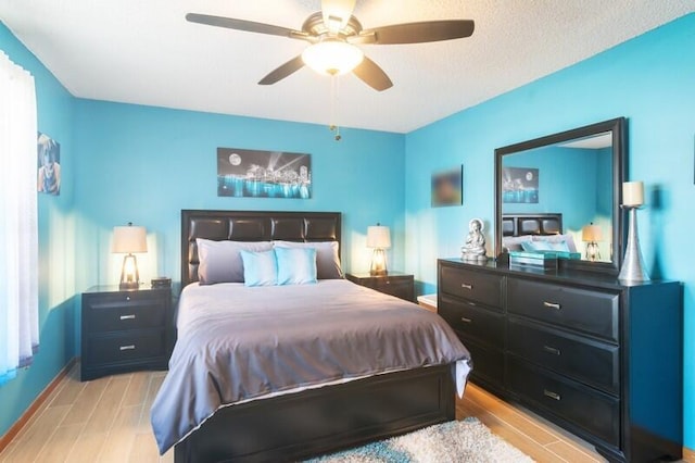 bedroom featuring a textured ceiling, light hardwood / wood-style flooring, and ceiling fan