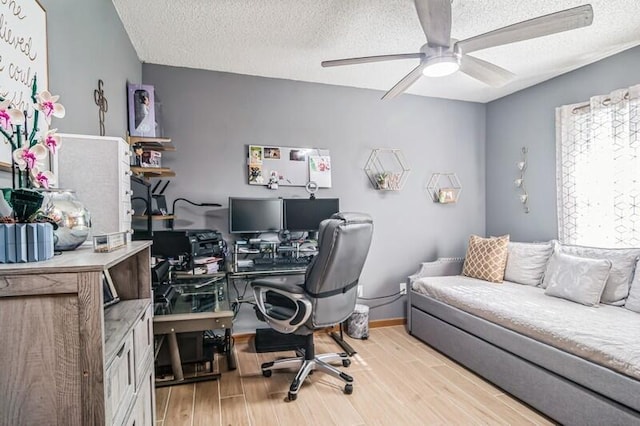 office area with a textured ceiling, light hardwood / wood-style flooring, and ceiling fan