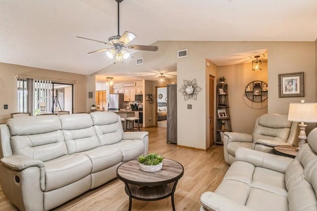 living room with light wood-type flooring, vaulted ceiling, and ceiling fan