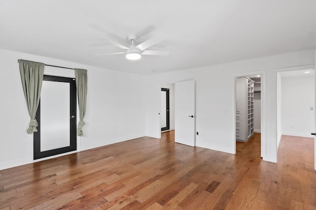 unfurnished room featuring wood finished floors, baseboards, and ceiling fan