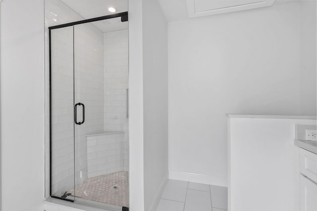 full bath featuring tile patterned floors, baseboards, a stall shower, and vanity