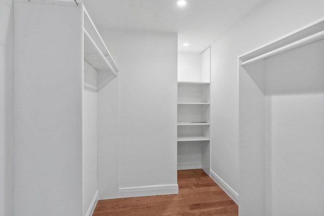 walk in closet with hardwood / wood-style floors