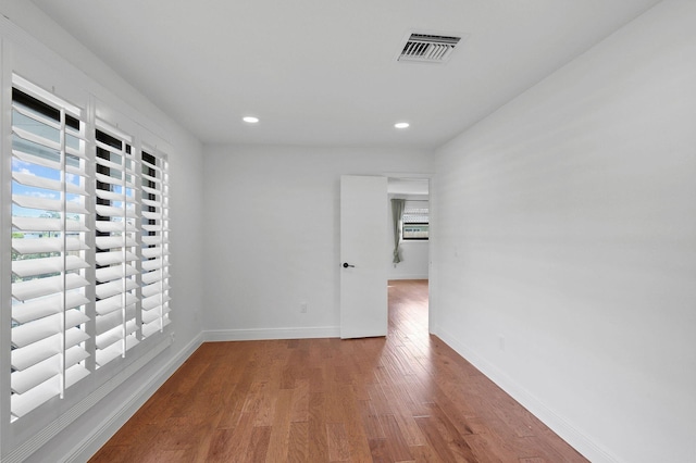 spare room featuring recessed lighting, wood finished floors, visible vents, and baseboards