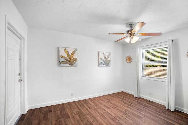 unfurnished room with ceiling fan, dark wood-type flooring, and a textured ceiling