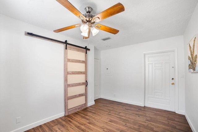 611 Monceaux Rd, West Palm Beach, FL 33405 - spare room with a barn door, ceiling fan, wood finished floors, and baseboards