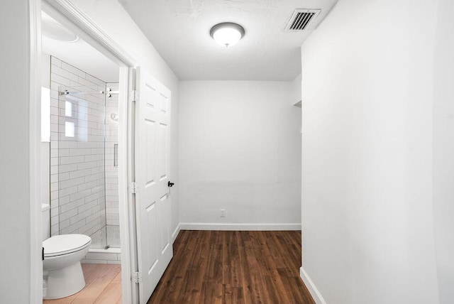 bathroom featuring hardwood / wood-style floors, toilet, and walk in shower