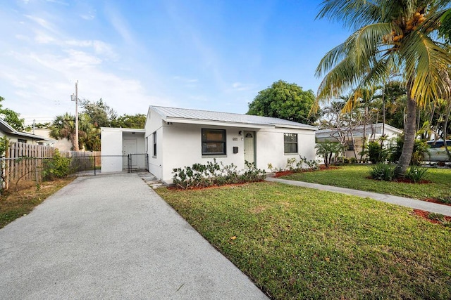 611 Monceaux Rd, West Palm Beach, FL 33405 - ranch-style house with stucco siding, driveway, a gate, and metal roof
