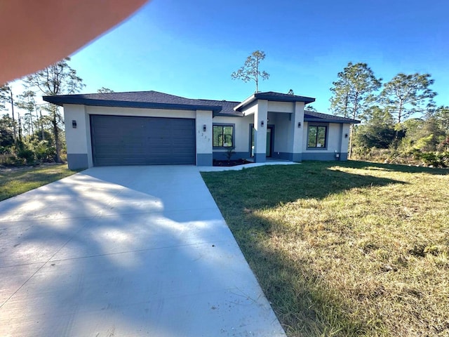 view of front of property with a garage and a front lawn