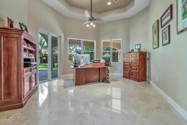 home office with french doors, a towering ceiling, a raised ceiling, and ceiling fan