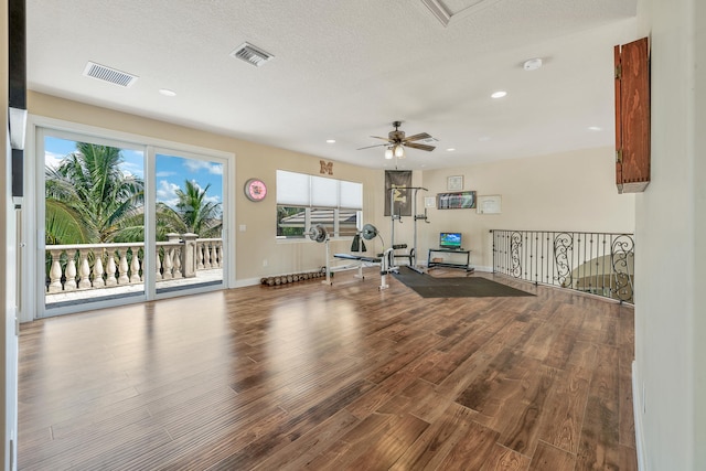 workout room with a textured ceiling, hardwood / wood-style flooring, and ceiling fan