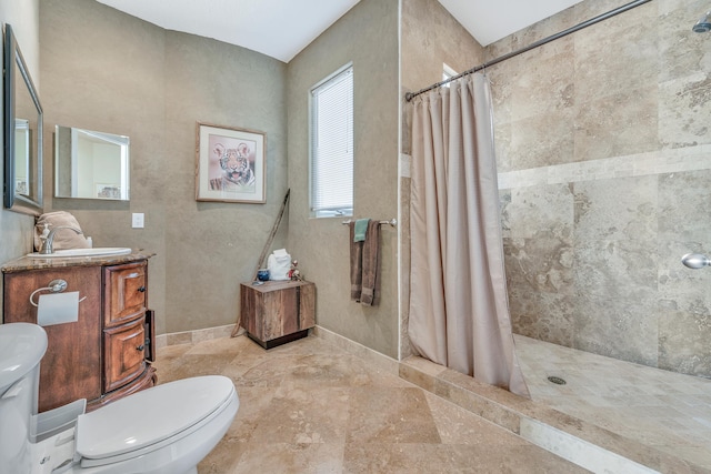 bathroom featuring toilet, vanity, and a shower with shower curtain