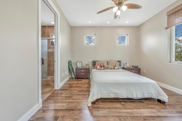 bedroom with ensuite bath, ceiling fan, and light hardwood / wood-style floors