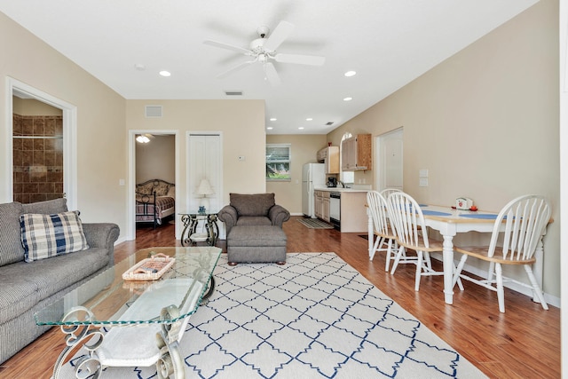 living room featuring hardwood / wood-style floors and ceiling fan