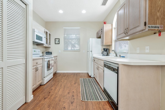 kitchen featuring white appliances, sink, and light hardwood / wood-style flooring