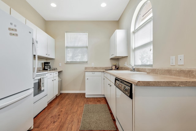 kitchen with white cabinetry, white appliances, sink, and light hardwood / wood-style flooring