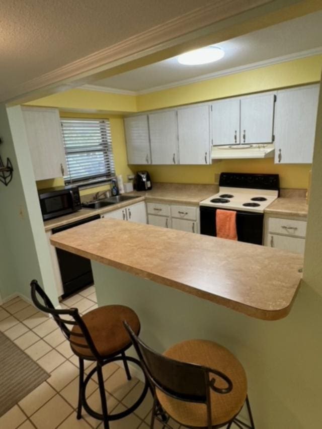 kitchen with white range with electric stovetop, sink, a breakfast bar area, and black dishwasher