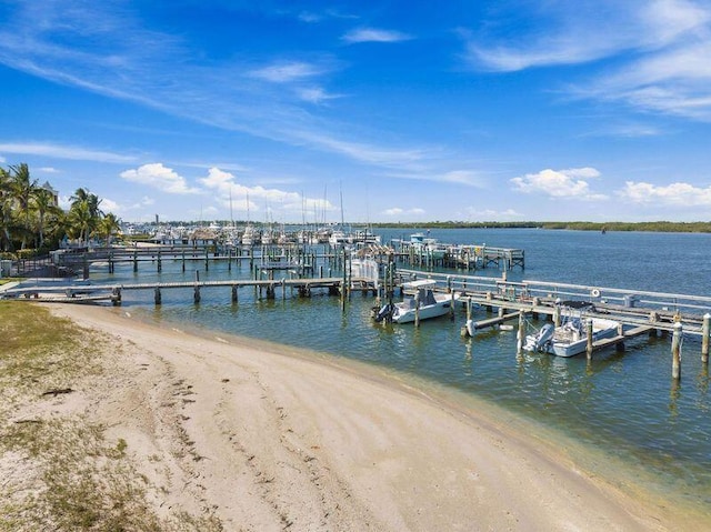 view of dock featuring a water view and a beach view