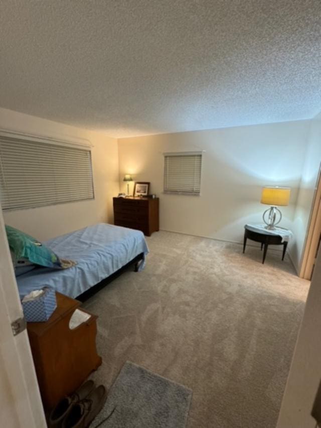 carpeted bedroom featuring a textured ceiling