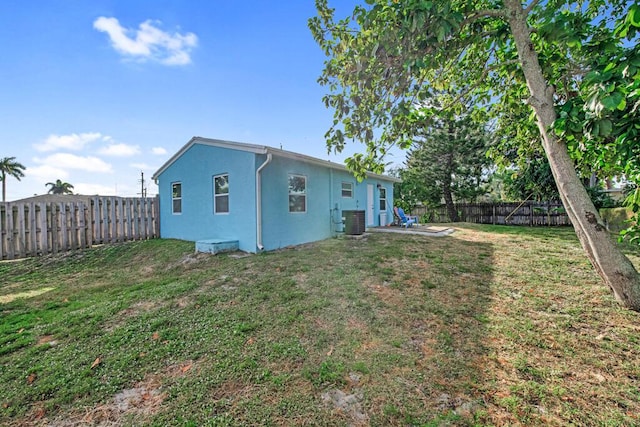 rear view of house with a yard and central AC