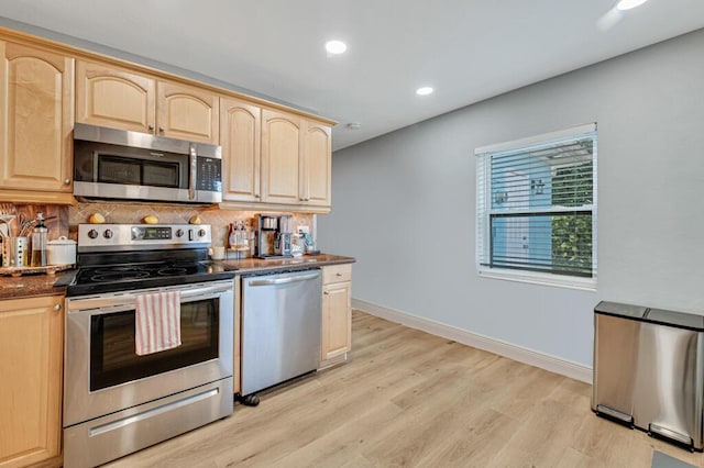 kitchen featuring light brown cabinets, backsplash, stainless steel appliances, and light hardwood / wood-style floors