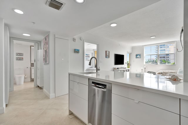 kitchen featuring white cabinets, dishwasher, light tile patterned flooring, and sink