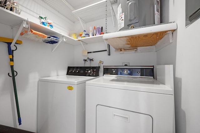 clothes washing area with washer and clothes dryer and water heater