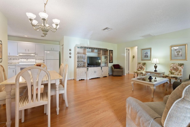 interior space featuring light hardwood / wood-style floors, a textured ceiling, and an inviting chandelier