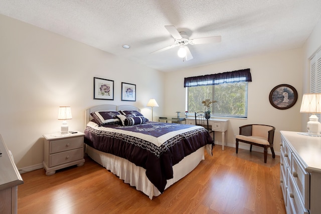 bedroom with ceiling fan, a textured ceiling, and light hardwood / wood-style flooring