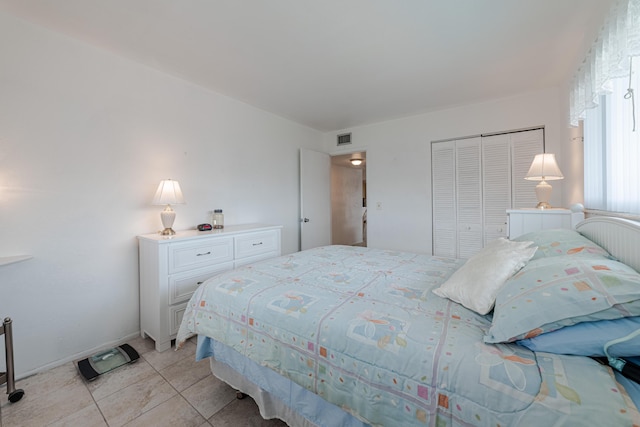 bedroom with a closet and light tile patterned flooring