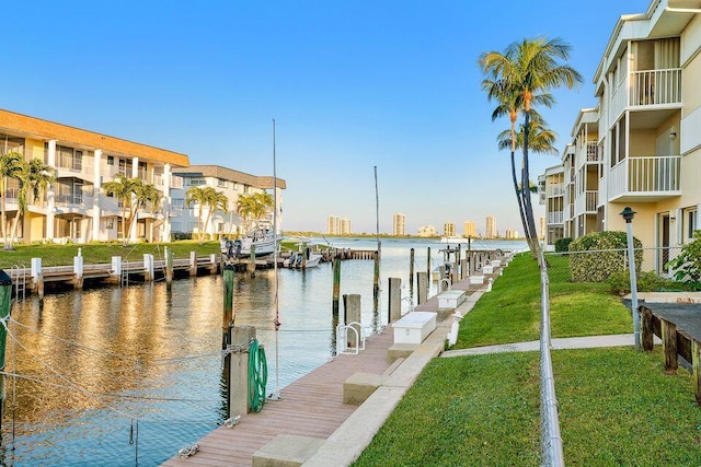 dock area featuring a water view and a lawn