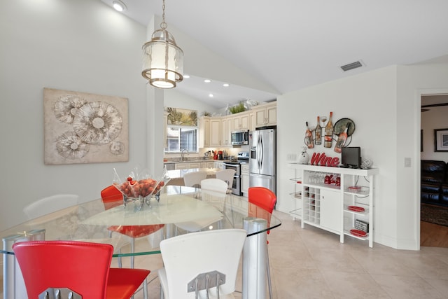 dining space featuring light tile patterned floors, sink, and high vaulted ceiling