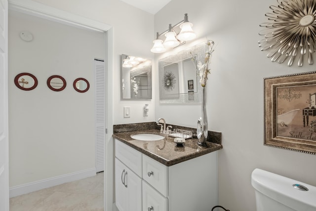 bathroom featuring tile patterned flooring, vanity, and toilet